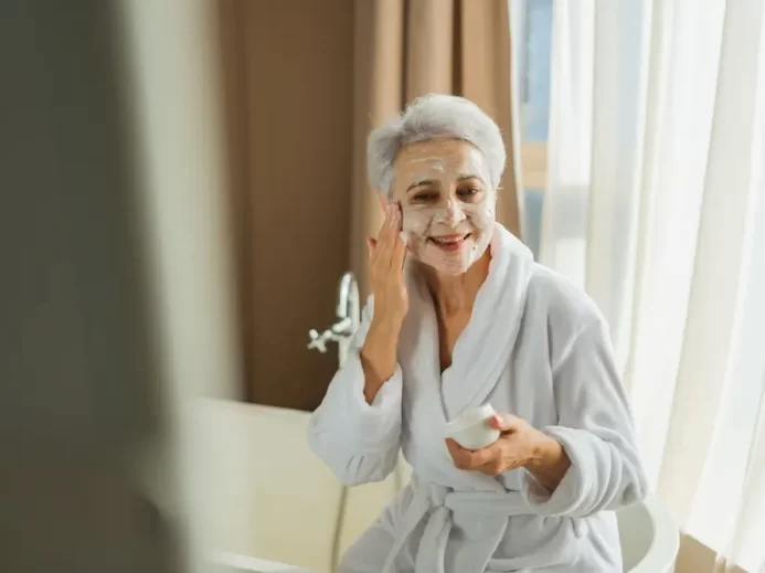 Starší žena používá zkrášlovací přípravek.