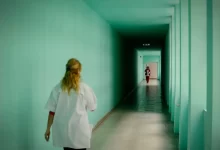 Zdravotní sestra na nemocniční chodbě.