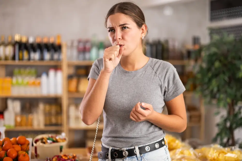 shutterstock_2560702249 - Pravda24 Žena v supermarketu kašle.