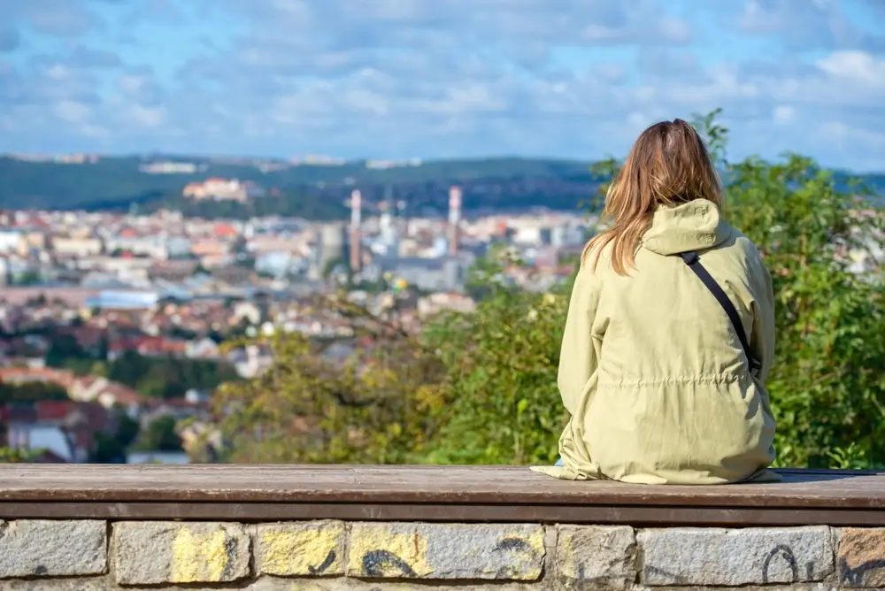 shutterstock_2569730375 - Pravda24 Žena sedí a užívá si výhledu na Brno.