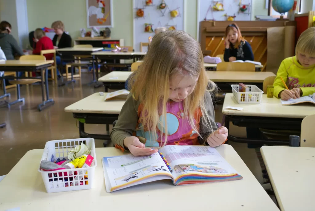 V severských zemích je důležitá individualita dětí. Zdroj: Shutterstock - Pravda24 Dívka ve třídě dívající se do učebnice.