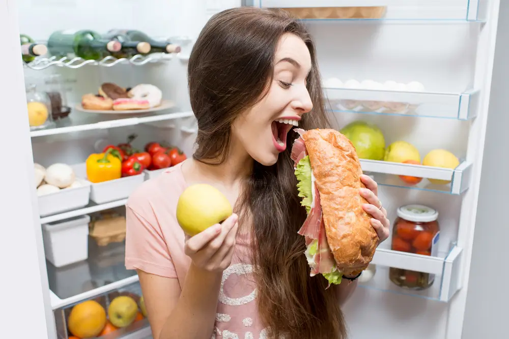 shutterstock_572938702 - Pravda24 Žena drží v rukou jablko a bagetu.
