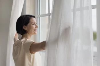 Žena otevírá okno