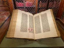 Otevřený exemplář slavné Gutenbergovy Bible s dvojsloupcovým tiskem a ručně doplněnou iluminací