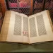 Otevřený exemplář slavné Gutenbergovy Bible s dvojsloupcovým tiskem a ručně doplněnou iluminací