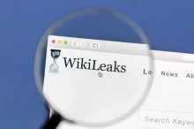 Detail loga WikiLeaks zobrazeného přes lupu na počítačové obrazovce