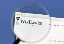 Detail loga WikiLeaks zobrazeného přes lupu na počítačové obrazovce