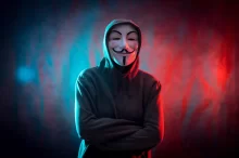 člen Anonymous - hacker s typickou maskou