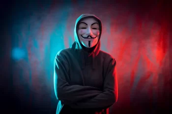 člen Anonymous - hacker s typickou maskou