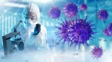 Laboratorní pracovnice v ochranném obleku pracuje s mikroskopem