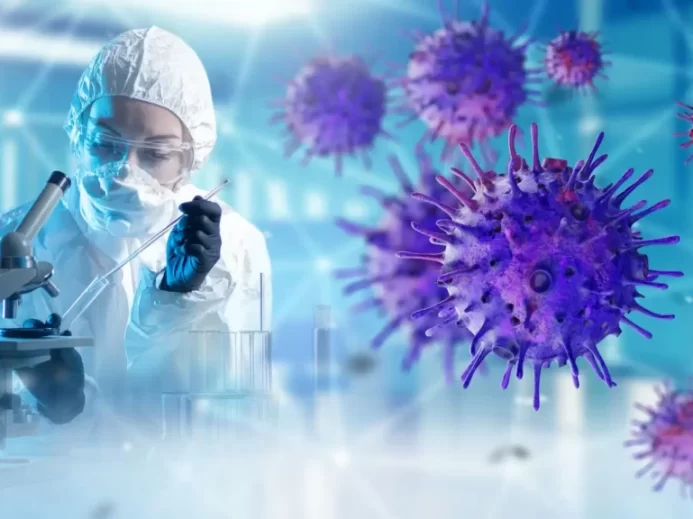 Laboratorní pracovnice v ochranném obleku pracuje s mikroskopem
