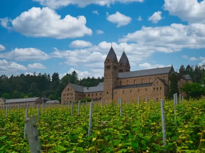 Pohled na klášter Eibingen v německém Porýní mezi vinicemi, jedno z míst spojených s působením Hildegardy z Bingenu