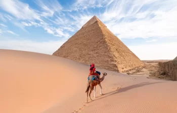 Pyramida v Egyptě a osoba na velbloudovi