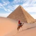 Pyramida v Egyptě a osoba na velbloudovi