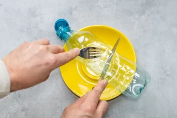 Plastové láhev na talíři příbor oběd