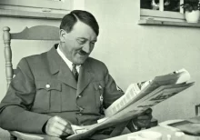 Adolf Hitler sedící v křesle při čtení novin
