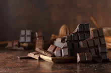 Tabulky hořké čokolády naaranžované na rustikálním podkladu