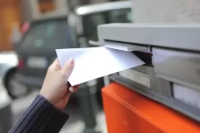 Dětská ruka chazuje dopis do poštovní schránky