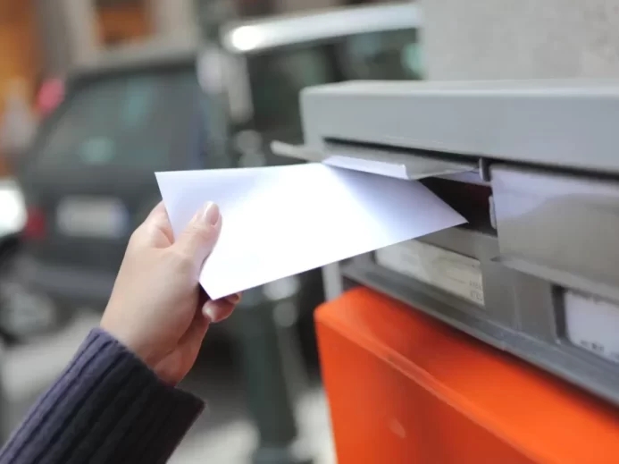Dětská ruka chazuje dopis do poštovní schránky