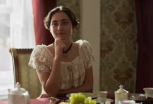 žena v dobovém kostýmu u stolu s jídlem