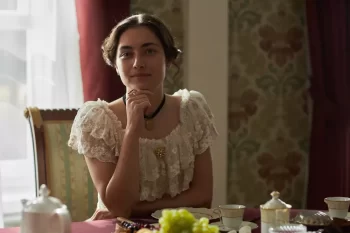 žena v dobovém kostýmu u stolu s jídlem