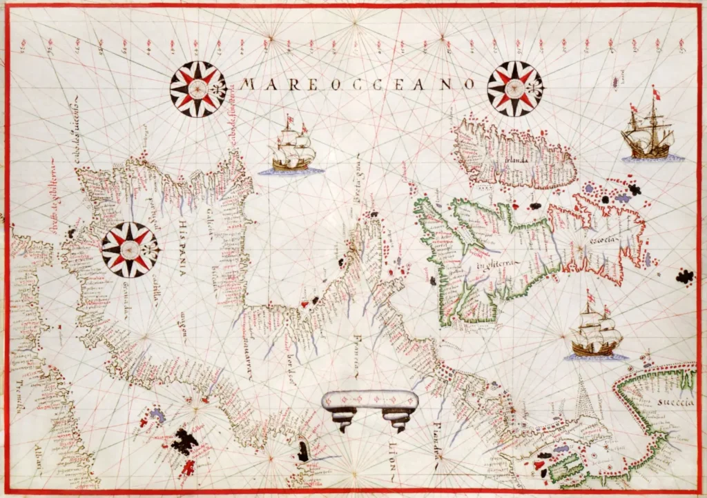 Historická portolánová mapa s detailně zakresleným evropským a atlantickým pobřežím, kompasovými růžicemi a kresbami lodí z éry námořních objevů