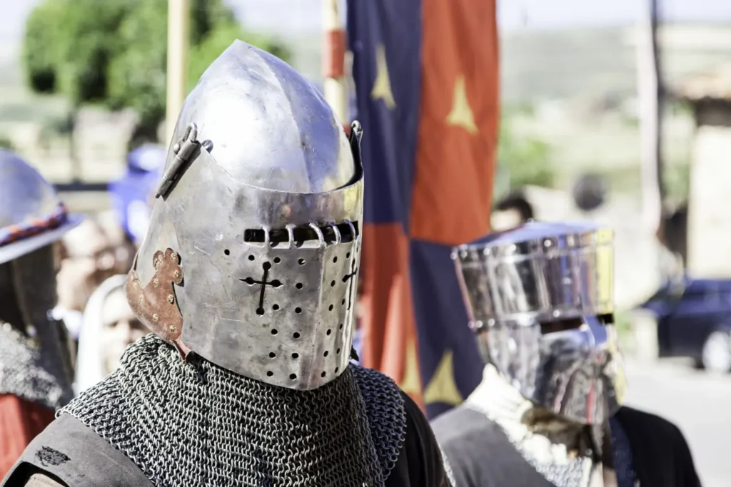 kupina mužů v těžkých rytířských přilbách a kroužkové zbroji při historickém průvodu