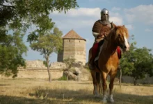 Středověký rytíř na koni u staré kamenné věže