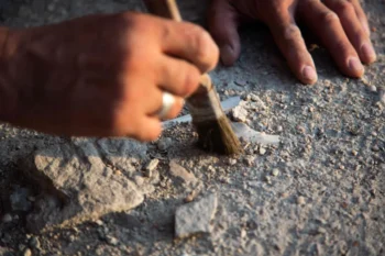 štětec oprašuje vykopávky