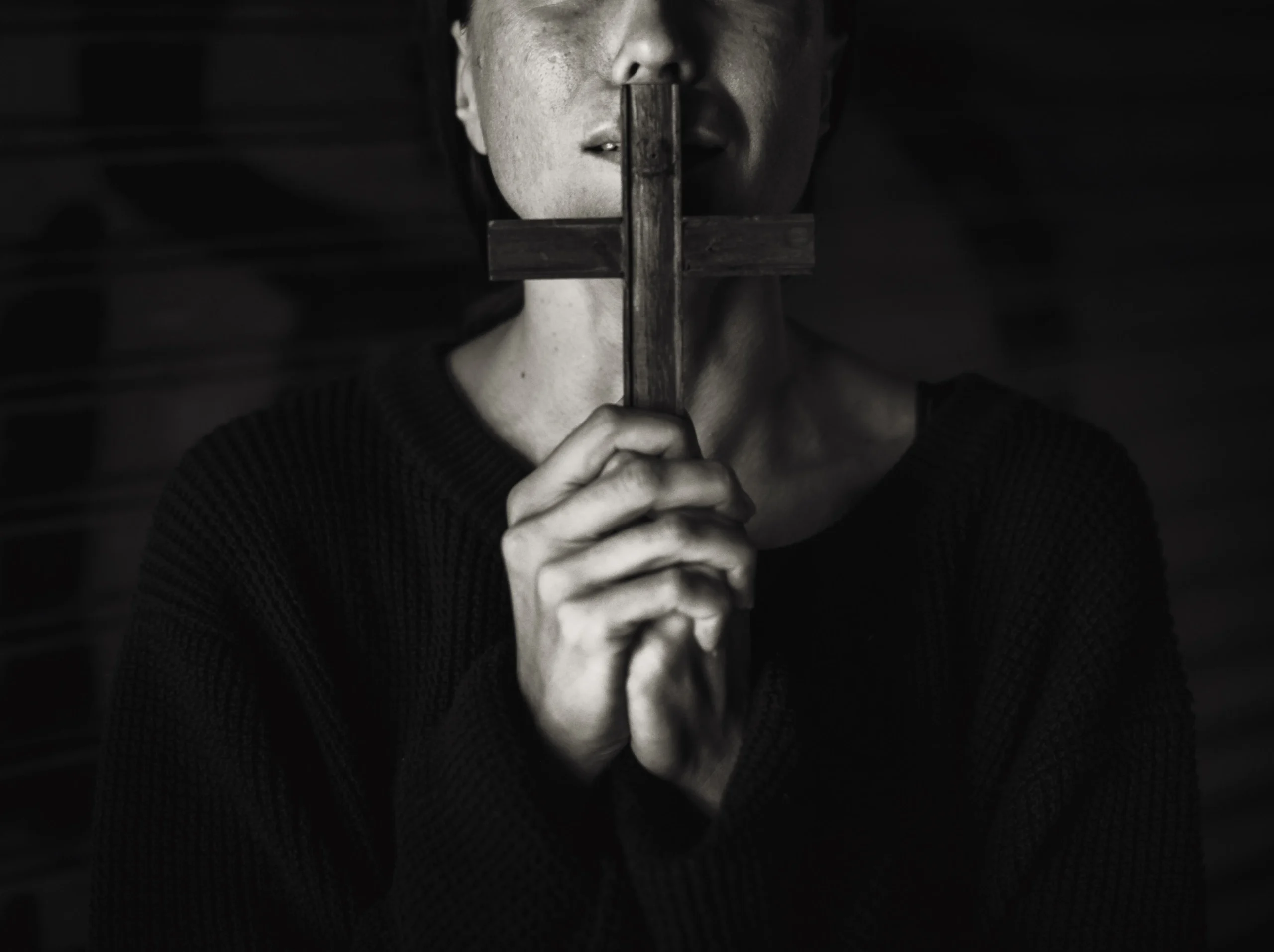 žena drží kříž